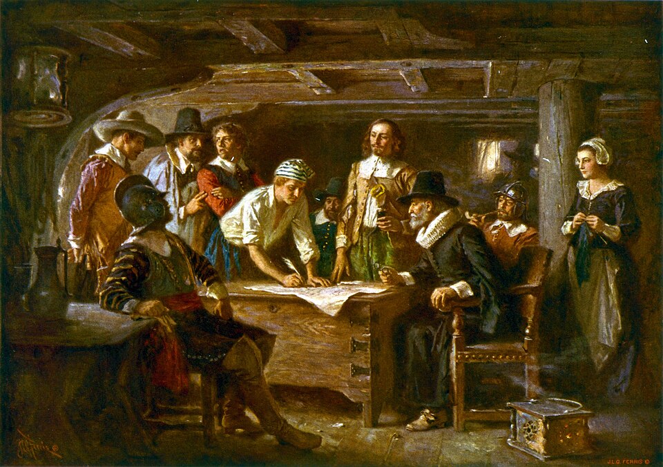 A painting depicting the signing of the Mayflower Compact aboard the ship in 1620